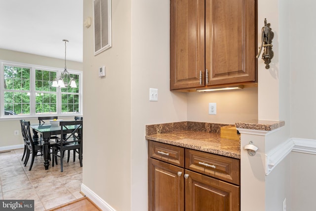 3740 Devin Ct, Huntingtown, MD 20639 - kitchen with baseboards, stone countertops, brown cabinetry, and pendant lighting