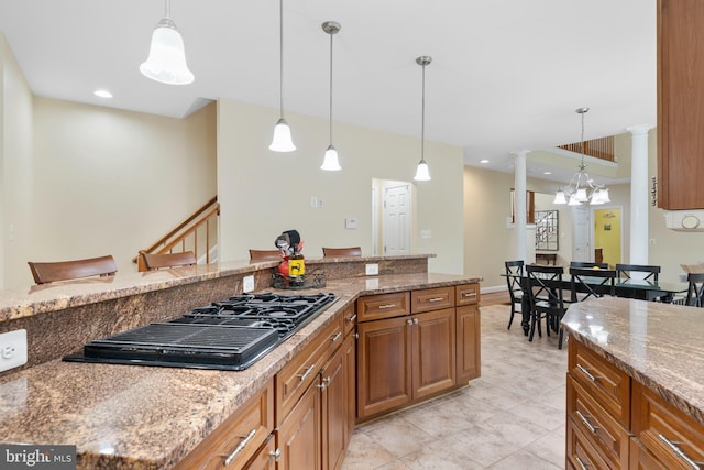 3740 Devin Ct, Huntingtown, MD 20639 - kitchen featuring decorative columns, brown cabinetry, black gas stovetop, hanging light fixtures, and light stone countertops