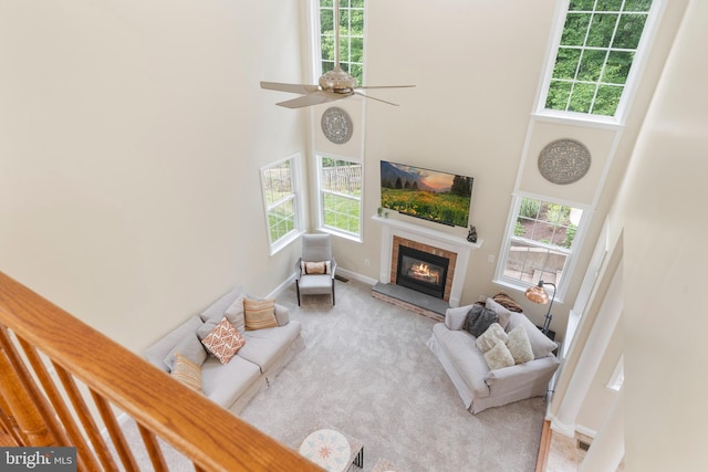 3740 Devin Ct, Huntingtown, MD 20639 - carpeted living area featuring a high ceiling, a fireplace, ceiling fan, and baseboards