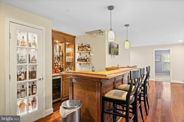 3740 Devin Ct, Huntingtown, MD 20639 - indoor wet bar featuring beverage cooler, dark wood-style floors, decorative light fixtures, and baseboards