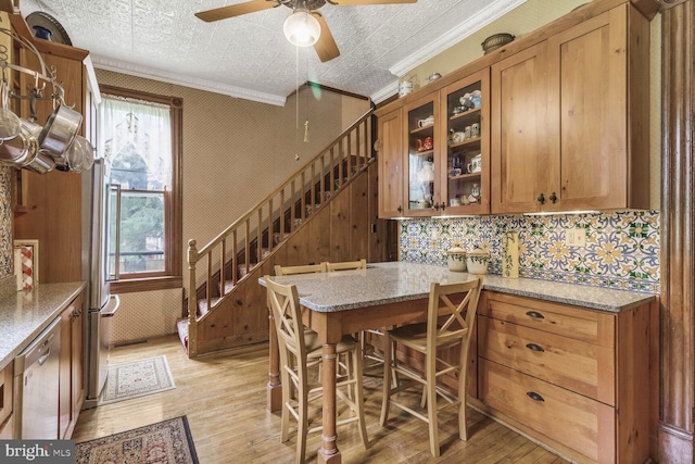 3911 Prospect St, Kensington, MD 20895 - kitchen featuring light wood finished floors, brown cabinetry, ceiling fan, glass insert cabinets, and ornamental molding