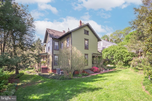3911 Prospect St, Kensington, MD 20895 - back of property featuring a chimney, central AC unit, and a yard