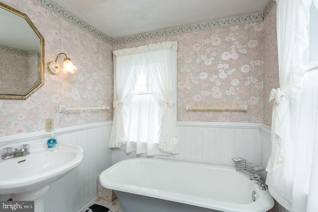 121 S Central St, Broadway, VA 22815 - bathroom with wallpapered walls, a wainscoted wall, a freestanding tub, and a sink