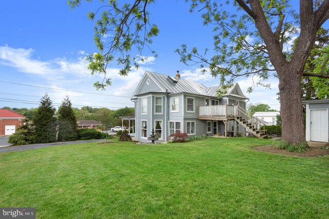121 S Central St, Broadway, VA 22815 - back of property with stairs, a yard, a chimney, a standing seam roof, and a wooden deck