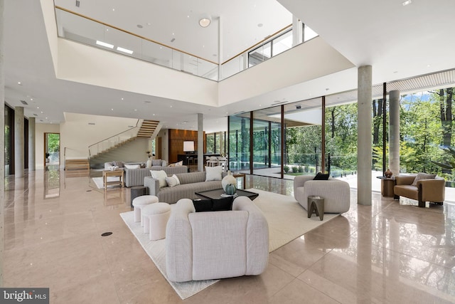 community lobby with expansive windows, a high ceiling, and stairway