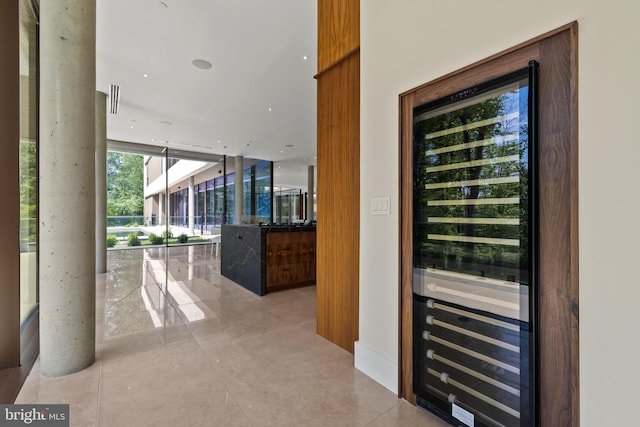 wine area with wine cooler, light tile patterned floors, and floor to ceiling windows