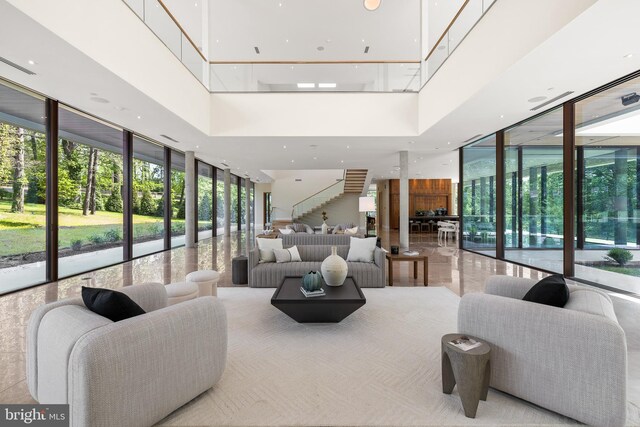building lobby featuring a towering ceiling, expansive windows, and stairway