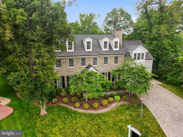 2125 Rampart Dr, Alexandria, VA 22308 - view of front of property with stone siding, a chimney, a front lawn, and decorative driveway