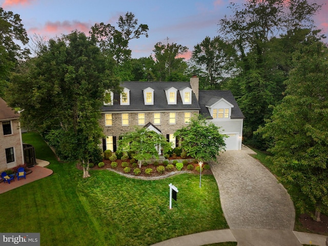 2125 Rampart Dr, Alexandria, VA 22308 - view of front facade with a chimney, driveway, an attached garage, and a front lawn