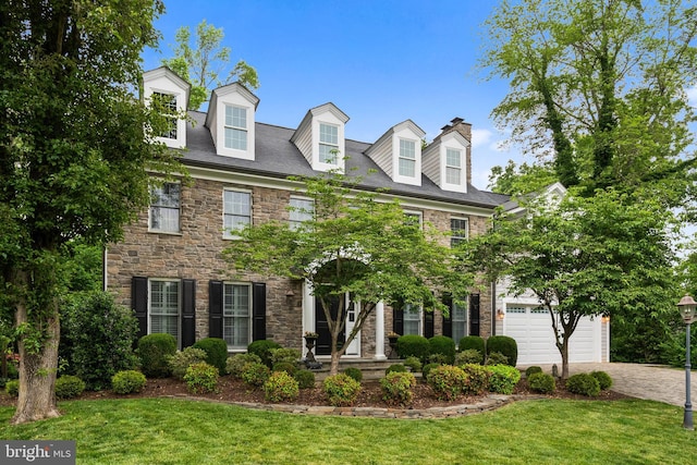 2125 Rampart Dr, Alexandria, VA 22308 - view of front of home featuring stone siding, a front yard, driveway, and a garage