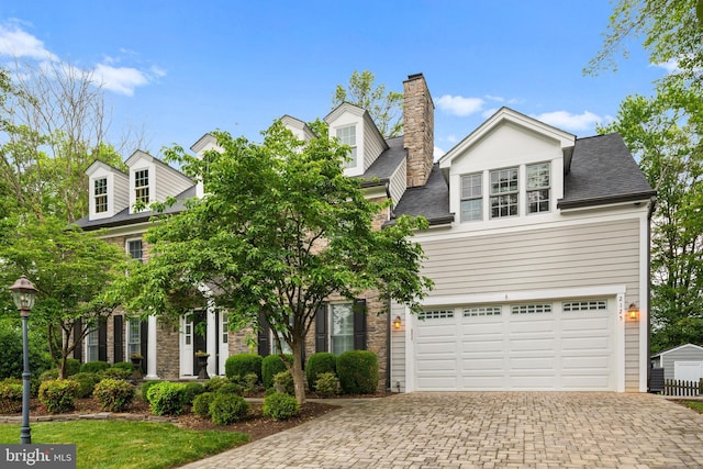 2125 Rampart Dr, Alexandria, VA 22308 - view of front of home with decorative driveway, a chimney, a garage, and stone siding