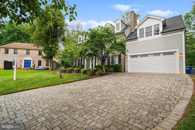 2125 Rampart Dr, Alexandria, VA 22308 - view of front of home with decorative driveway, a front yard, an attached garage, a chimney, and a shingled roof