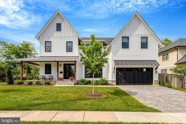 modern inspired farmhouse featuring board and batten siding, a standing seam roof, a porch, and decorative driveway