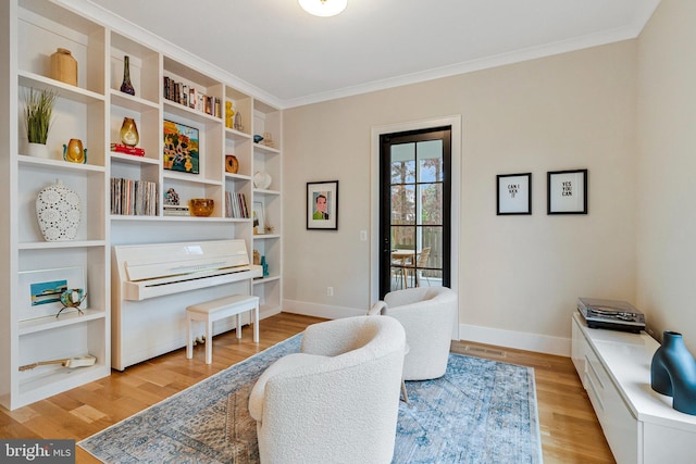 living area featuring light wood finished floors, ornamental molding, and baseboards