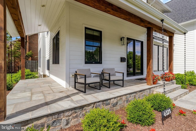 view of patio / terrace featuring a porch and fence