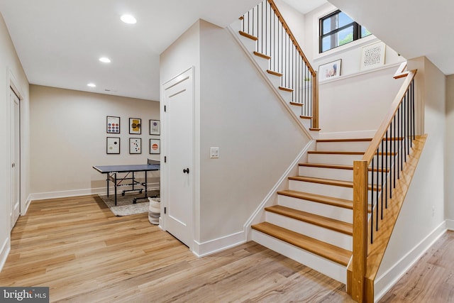 stairway featuring wood finished floors, baseboards, and recessed lighting