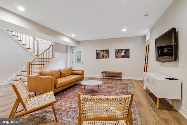 living room featuring stairs, light wood-style flooring, recessed lighting, and baseboards