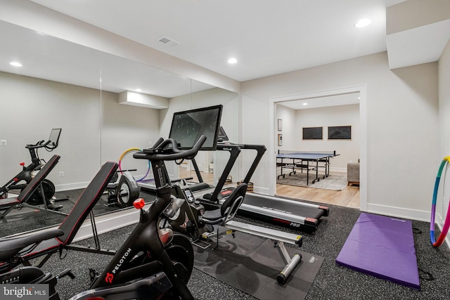 workout room with recessed lighting, baseboards, and wood finished floors