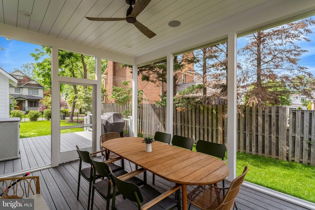 sunroom / solarium with ceiling fan and outdoor dining space