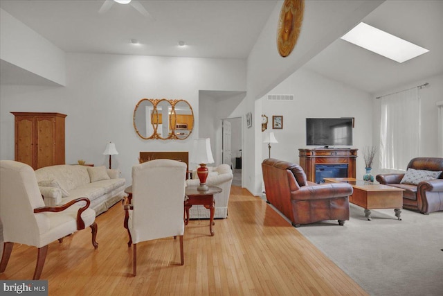 4304 Wheelwright Trl, Downingtown, PA 19335 - living room featuring a fireplace, lofted ceiling, ceiling fan, a skylight, and light wood-style floors