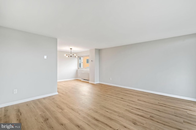 4520 King St Unit 609, Alexandria, VA 22302 - unfurnished living room with a chandelier, light wood-type flooring, and baseboards