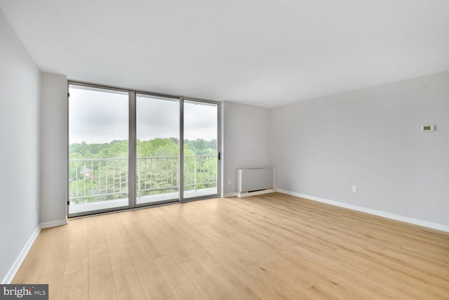 4520 King St Unit 609, Alexandria, VA 22302 - unfurnished room featuring a wall of windows, light wood-style flooring, baseboards, and radiator heating unit