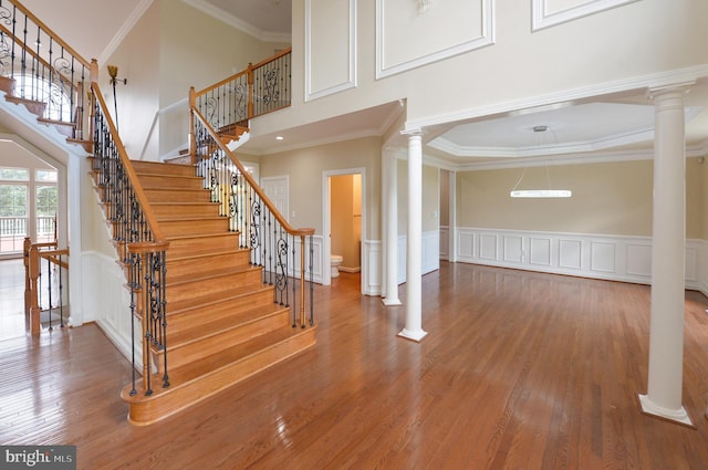 6 Applewood Ct, Hainesport, NJ 08036 - staircase with decorative columns, wood finished floors, a towering ceiling, crown molding, and a decorative wall