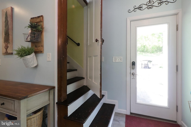 doorway with stairs, baseboards, and wood finished floors