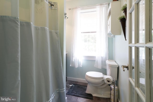 full bath featuring toilet and baseboards