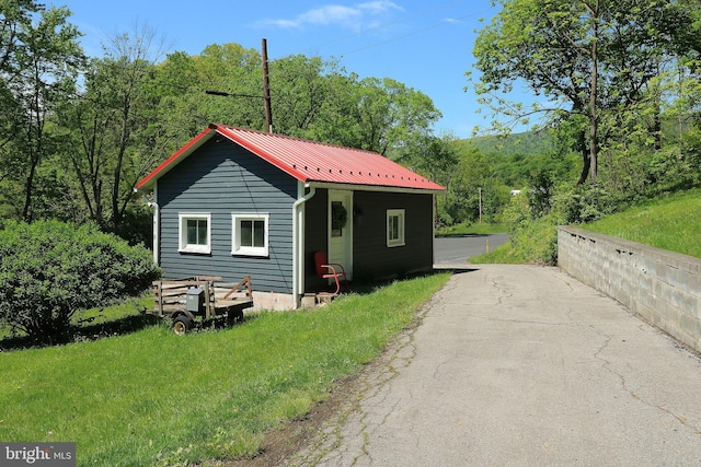 view of front of house with metal roof and a forest view