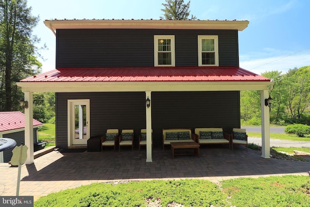 rear view of property featuring metal roof, central AC, an outdoor hangout area, and a patio area