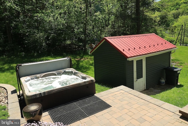 view of patio featuring a hot tub and a wooded view
