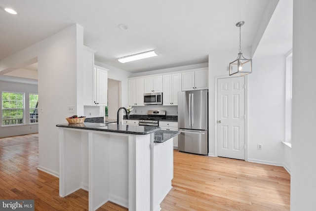 20683 Waterfall Branch Ter, Sterling, VA 20165 - kitchen with appliances with stainless steel finishes, light wood-style floors, white cabinets, a peninsula, and dark stone countertops