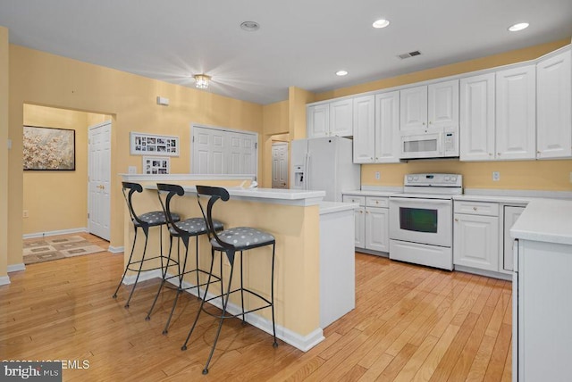 52 Whitewater Dr, Barnegat, NJ 08005 - kitchen featuring white appliances, white cabinets, a kitchen bar, a center island, and recessed lighting