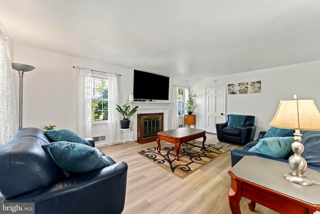 living area featuring light wood-style flooring and a fireplace