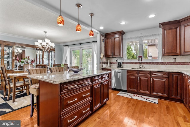 kitchen with stainless steel dishwasher, french doors, a breakfast bar area, crown molding, and pendant lighting