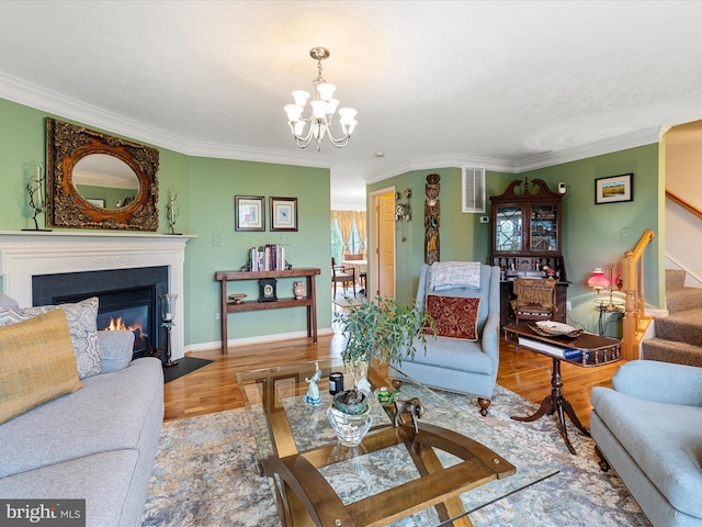 2079 Stoneleigh Dr, Winchester, VA 22601 - living area featuring stairway, wood finished floors, a chandelier, a fireplace with flush hearth, and ornamental molding