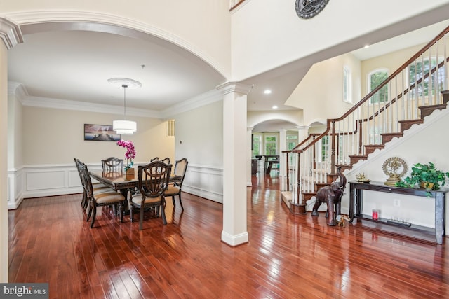 13330 Darnestown Rd, Darnestown, MD 20878 - dining area featuring decorative columns, arched walkways, stairs, wood-type flooring, and wainscoting