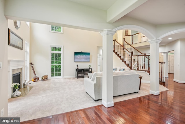 13330 Darnestown Rd, Darnestown, MD 20878 - living area with ornate columns, hardwood / wood-style flooring, arched walkways, a high end fireplace, and stairway