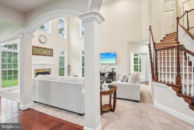 13330 Darnestown Rd, Darnestown, MD 20878 - living area featuring decorative columns, a towering ceiling, healthy amount of natural light, stairs, and a fireplace