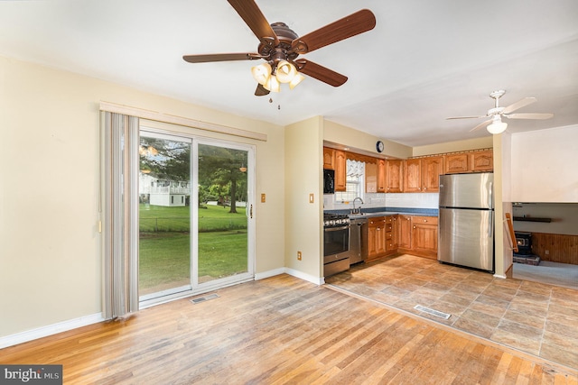 9005 Fieldchat Rd, Baltimore, MD 21236 - kitchen with stainless steel appliances, a ceiling fan, brown cabinets, light wood finished floors, and a sink