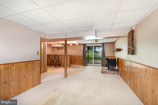 9005 Fieldchat Rd, Baltimore, MD 21236 - below grade area featuring a wood stove, a wainscoted wall, wood walls, carpet floors, and a dry bar