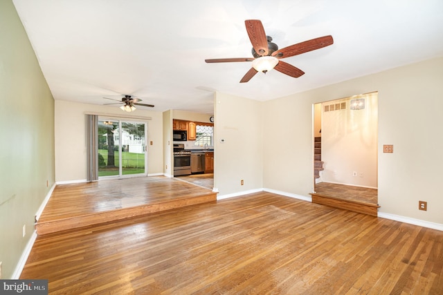 9005 Fieldchat Rd, Baltimore, MD 21236 - unfurnished living room featuring a ceiling fan, light wood finished floors, stairway, and baseboards