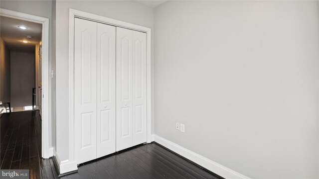 1321 W St SE, Washington, DC 20020 - unfurnished bedroom with a closet, dark wood-style flooring, and baseboards