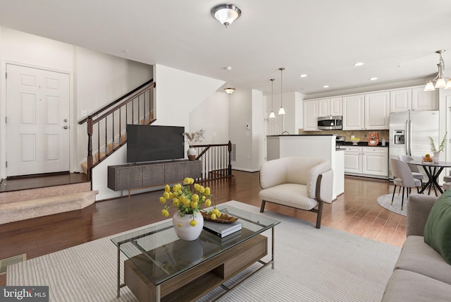 42189 Shorecrest Ter, Aldie, VA 20105 - living area with dark wood-style floors, recessed lighting, a chandelier, and stairs