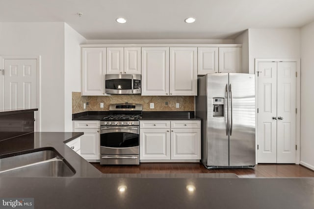 42189 Shorecrest Ter, Aldie, VA 20105 - kitchen featuring appliances with stainless steel finishes, dark countertops, white cabinetry, a sink, and recessed lighting