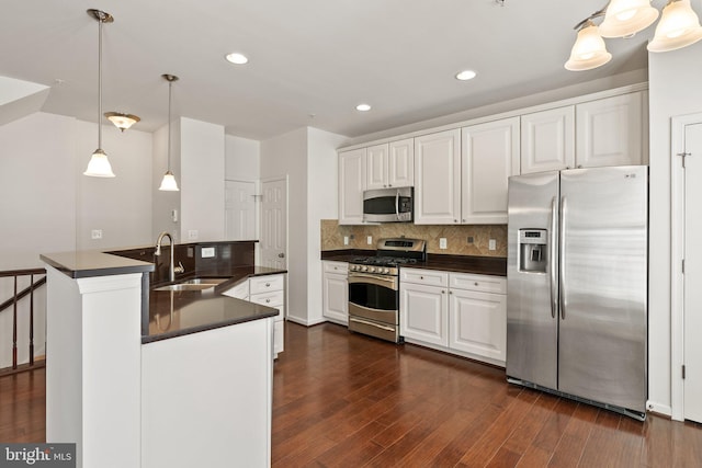 42189 Shorecrest Ter, Aldie, VA 20105 - kitchen with appliances with stainless steel finishes, a sink, dark countertops, backsplash, and dark wood-style flooring