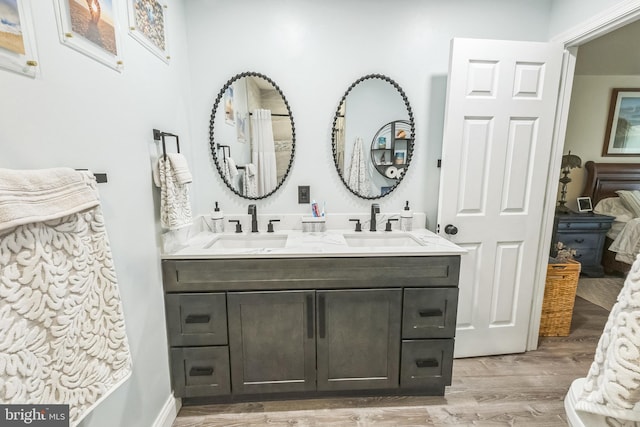 full bath featuring wood finished floors and double vanity