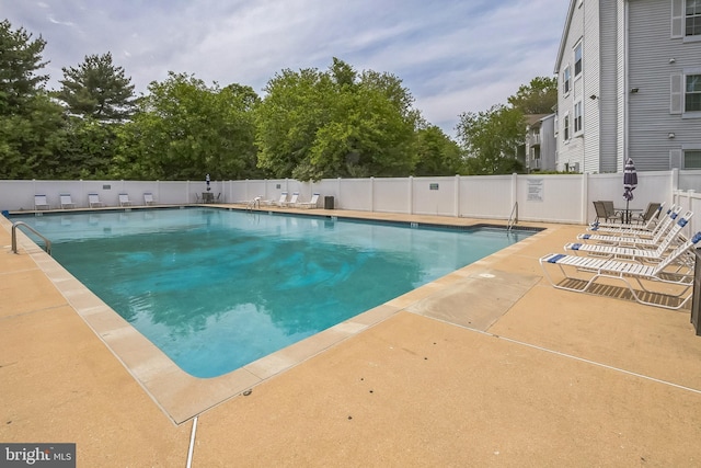 community pool with fence and a patio