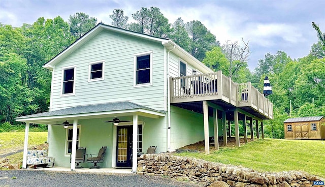 686 Snow Mountain Rd, Stanardsville, VA 22973 - view of front of house with ceiling fan, a storage shed, an outdoor structure, a wooden deck, and a front lawn